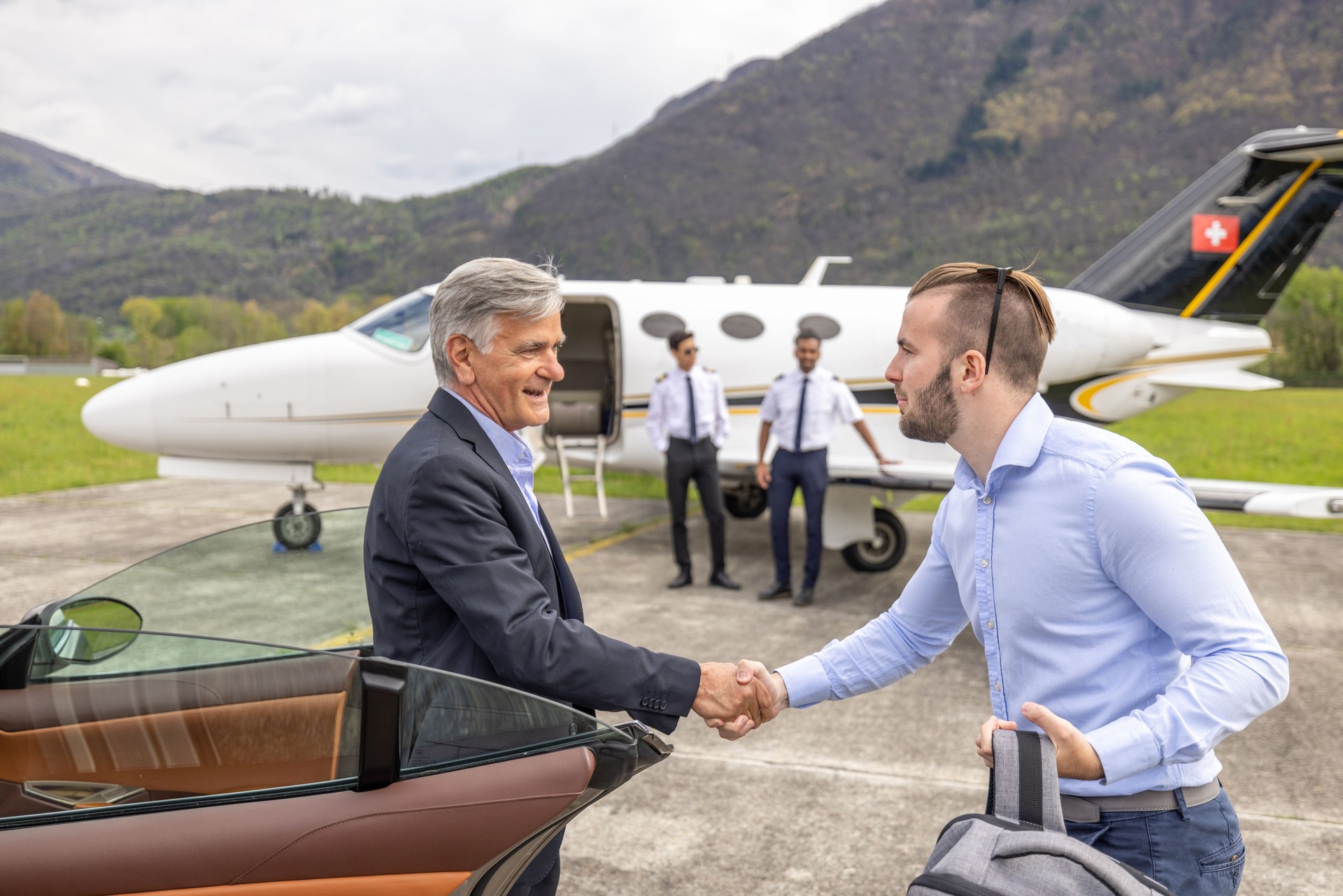 Businessman gets out of luxury car ready to board a private jet